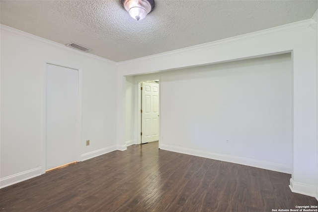 spare room with dark hardwood / wood-style flooring, ornamental molding, and a textured ceiling