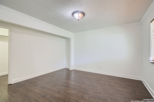 empty room featuring dark hardwood / wood-style floors, ornamental molding, and a textured ceiling