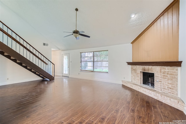 unfurnished living room with a textured ceiling, hardwood / wood-style flooring, a brick fireplace, and ceiling fan