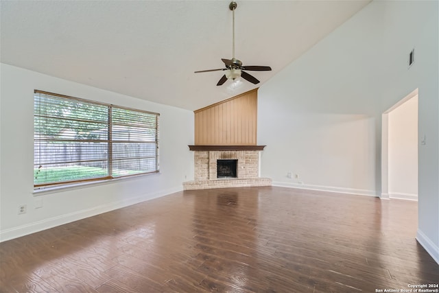 unfurnished living room featuring ceiling fan, high vaulted ceiling, dark hardwood / wood-style floors, and a brick fireplace