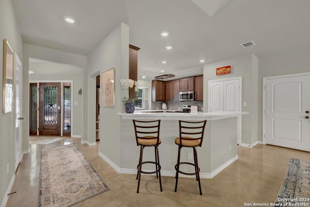 120 Sierra Way, Canyon Lake, TX 78133 - kitchen featuring tasteful backsplash, kitchen peninsula, a kitchen breakfast bar, and appliances with stainless steel finishes