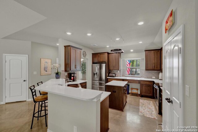 120 Sierra Way, Canyon Lake, TX 78133 - kitchen with a center island, appliances with stainless steel finishes, tasteful backsplash, kitchen peninsula, and a breakfast bar area