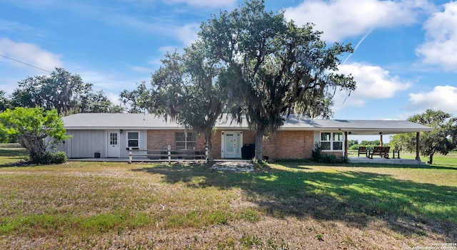 ranch-style home with a front yard and a patio area