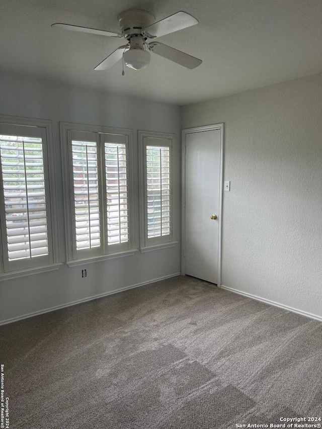 unfurnished room with carpet floors, plenty of natural light, and ceiling fan