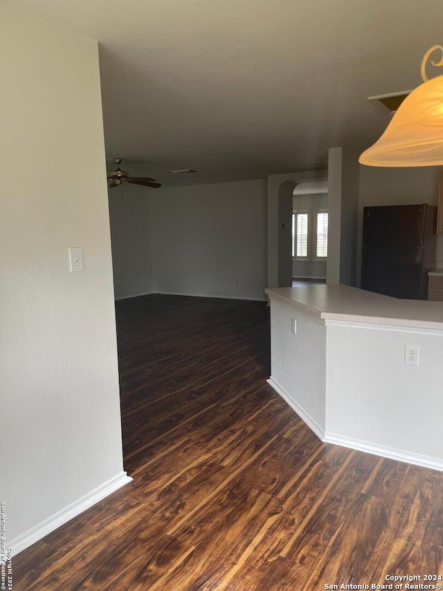 unfurnished room with ceiling fan and dark wood-type flooring