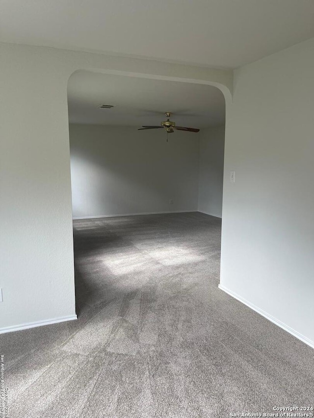 carpeted empty room featuring ceiling fan