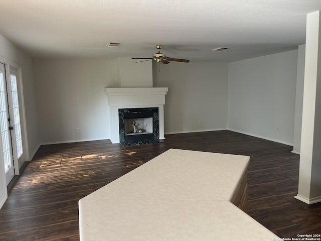 unfurnished living room with a high end fireplace, dark hardwood / wood-style floors, and ceiling fan