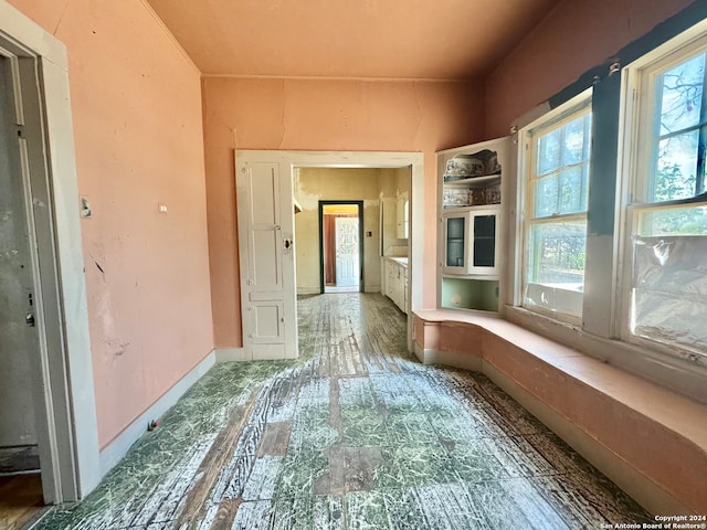 corridor with tile flooring and a healthy amount of sunlight