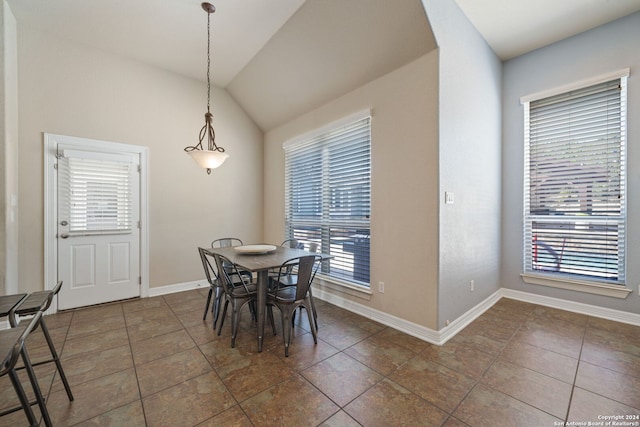 tiled dining room with vaulted ceiling and a wealth of natural light