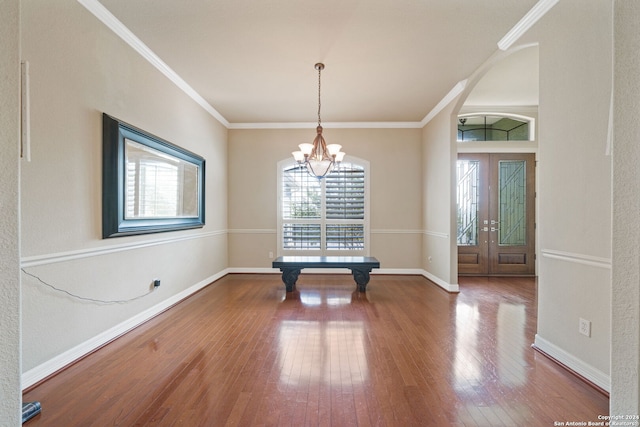 unfurnished dining area with a wealth of natural light, a notable chandelier, and hardwood / wood-style flooring