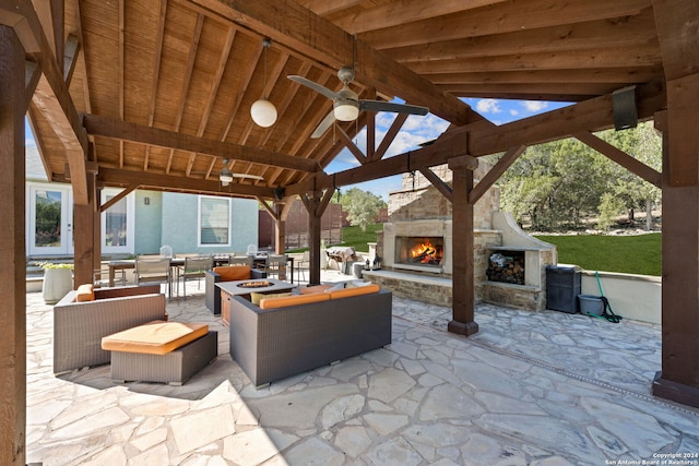 view of patio featuring a gazebo, ceiling fan, and an outdoor living space with a fireplace