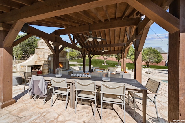 view of patio / terrace featuring an outdoor stone fireplace and ceiling fan