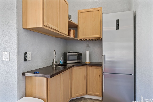 kitchen featuring sink, light brown cabinets, stainless steel appliances, and a textured ceiling