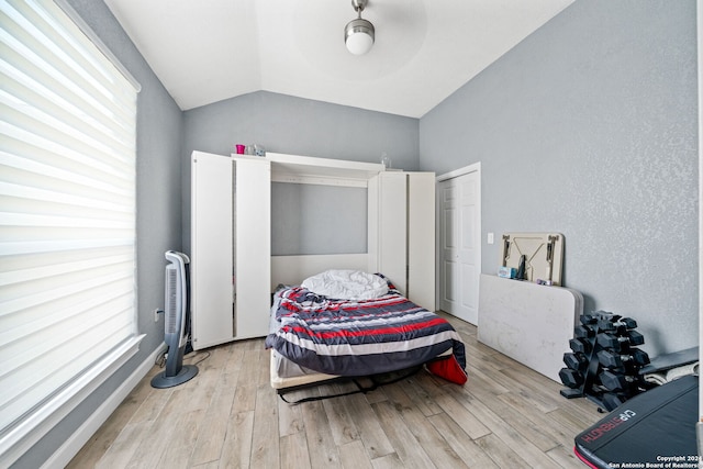 bedroom featuring ceiling fan, vaulted ceiling, and light wood-type flooring