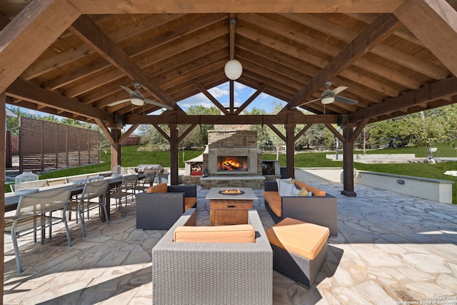 view of patio / terrace featuring a gazebo, ceiling fan, and an outdoor living space with a fireplace