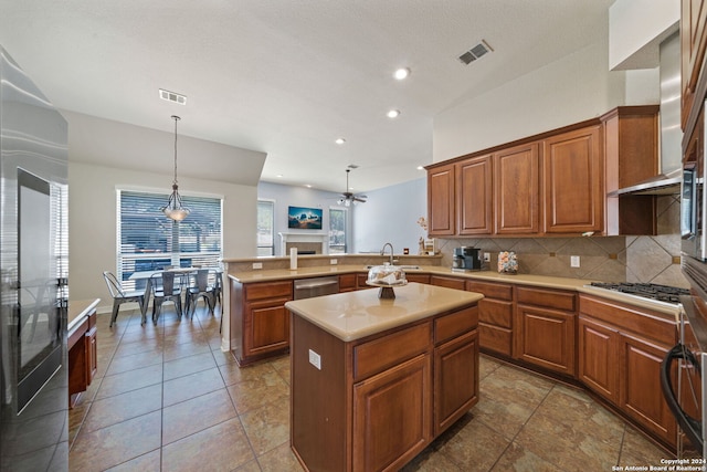 kitchen with a kitchen island, wall chimney range hood, kitchen peninsula, appliances with stainless steel finishes, and tasteful backsplash