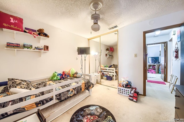 carpeted bedroom featuring ceiling fan, a textured ceiling, and a closet