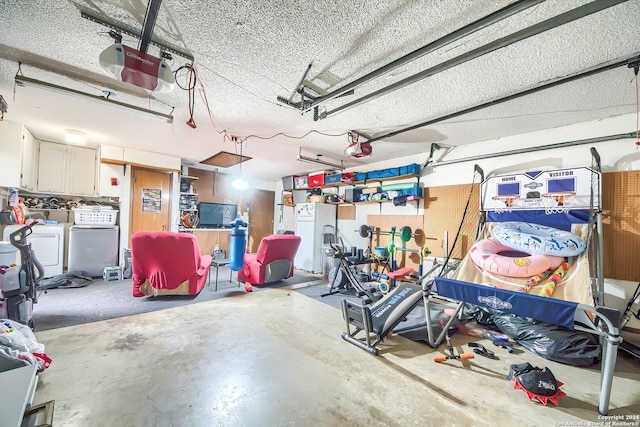 garage with white fridge, a garage door opener, and washer and clothes dryer