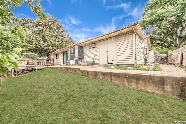 rear view of property with a lawn and a deck