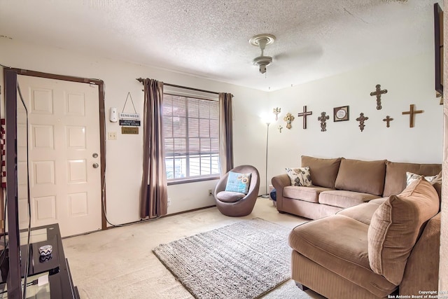 living room featuring a textured ceiling, carpet floors, and ceiling fan