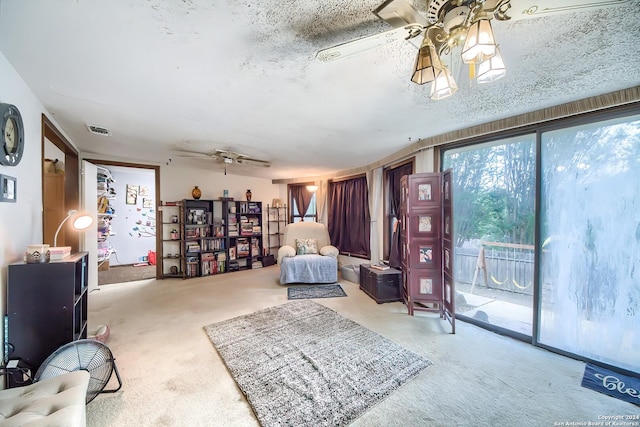 sitting room with carpet flooring, ceiling fan, and a textured ceiling