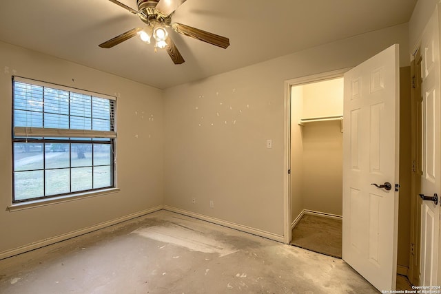 unfurnished bedroom with ceiling fan, a walk in closet, and a closet