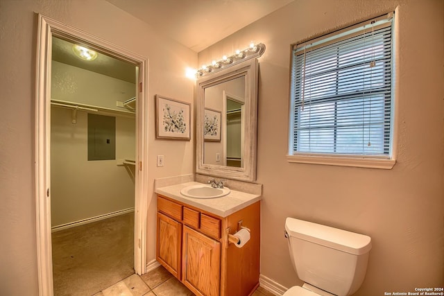 bathroom with tile patterned flooring, vanity, a healthy amount of sunlight, and toilet