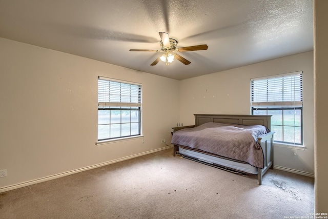 unfurnished bedroom featuring carpet, ceiling fan, and a textured ceiling