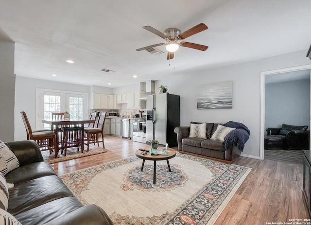 living room with ceiling fan and light hardwood / wood-style floors