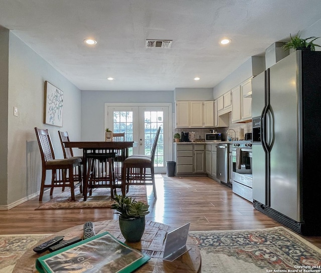 kitchen featuring french doors, stainless steel appliances, a textured ceiling, and hardwood / wood-style flooring