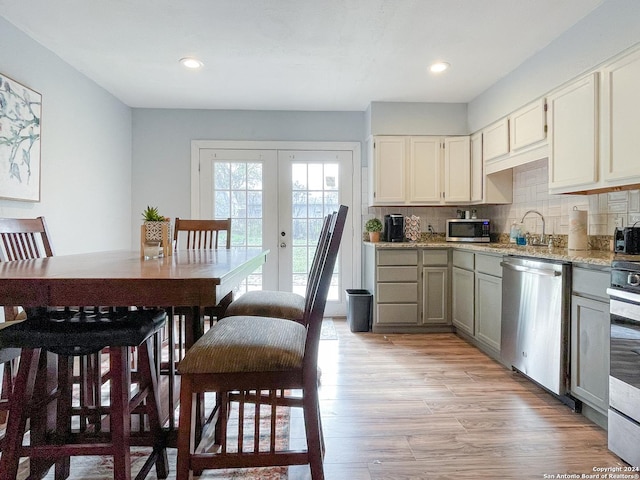 kitchen featuring french doors, sink, decorative backsplash, appliances with stainless steel finishes, and light hardwood / wood-style floors