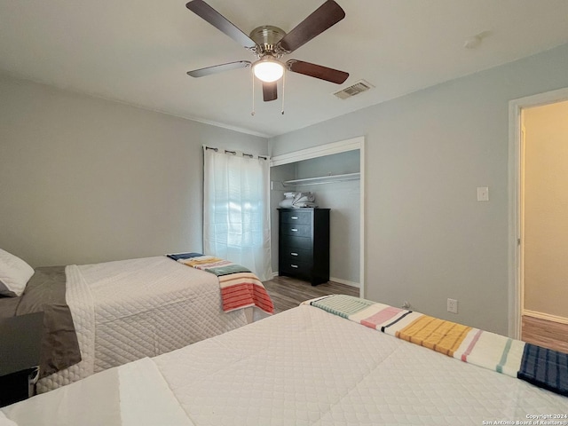 bedroom with wood-type flooring, a closet, and ceiling fan