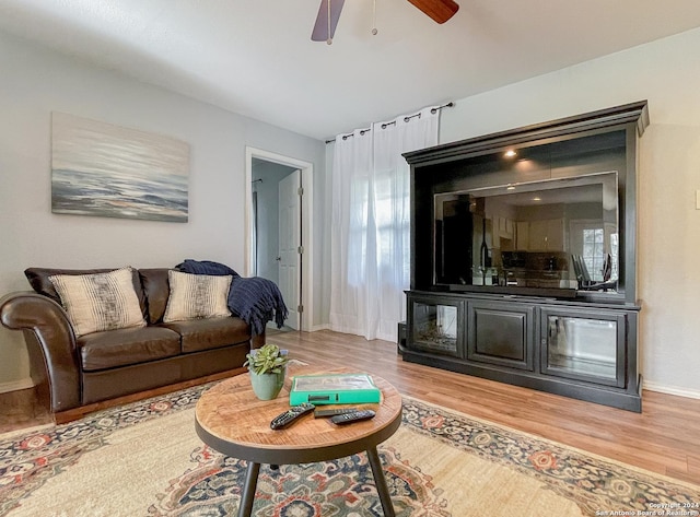 living room featuring light wood-type flooring and ceiling fan