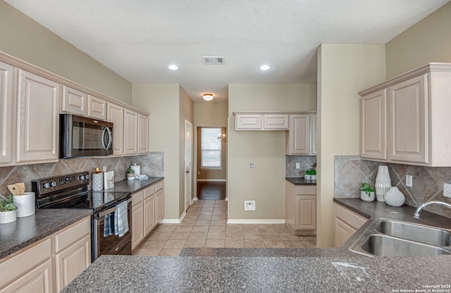 kitchen with tasteful backsplash, black electric range, a textured ceiling, light tile floors, and sink