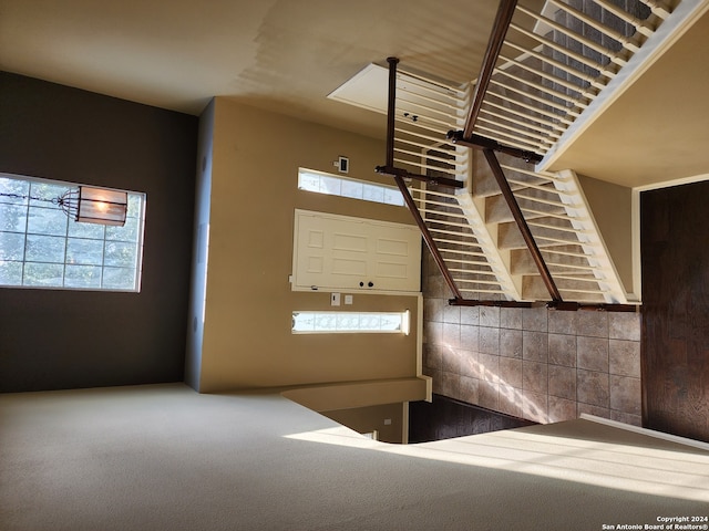 interior space with plenty of natural light, a towering ceiling, and carpet floors