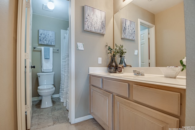 bathroom with tile flooring, toilet, and vanity