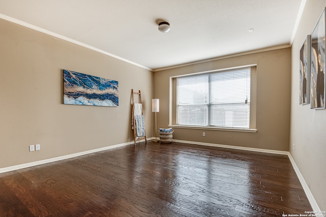 spare room featuring dark hardwood / wood-style flooring and crown molding