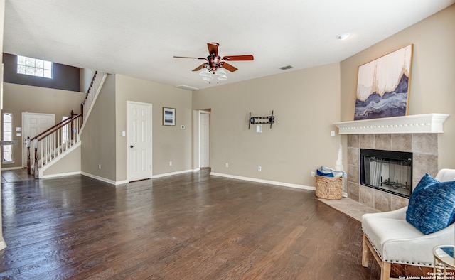 living room with a fireplace, ceiling fan, and dark hardwood / wood-style flooring