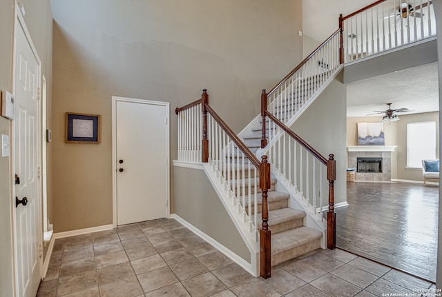 foyer with hardwood / wood-style flooring, a tile fireplace, and ceiling fan