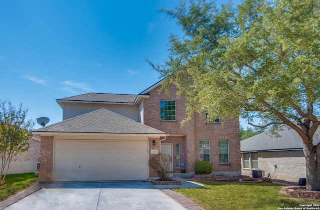 view of front of property with a front lawn, a garage, and central AC unit