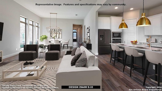 living room with dark hardwood / wood-style flooring and a notable chandelier