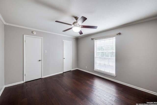 empty room with ceiling fan, crown molding, and dark wood-type flooring