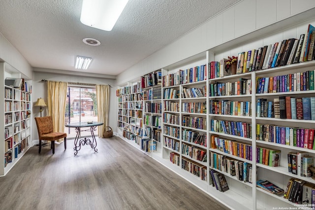 sitting room featuring wood-type flooring and a textured ceiling