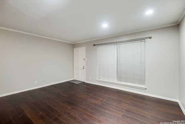 empty room featuring ornamental molding and dark hardwood / wood-style flooring