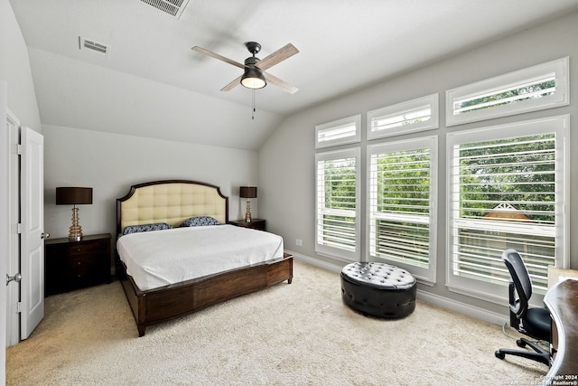 carpeted bedroom with multiple windows, ceiling fan, and vaulted ceiling