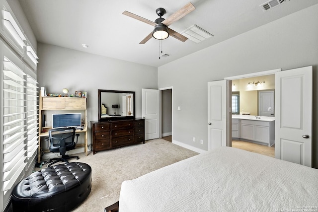 bedroom with multiple windows, light colored carpet, ensuite bath, and ceiling fan