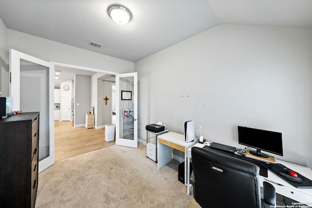 carpeted office featuring french doors and lofted ceiling