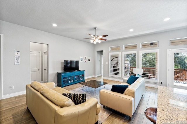 living room with ceiling fan and a textured ceiling