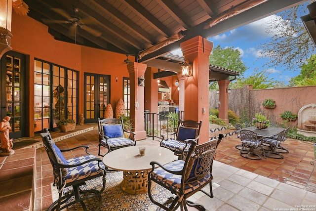 view of patio / terrace with outdoor dining space, fence, a ceiling fan, and french doors