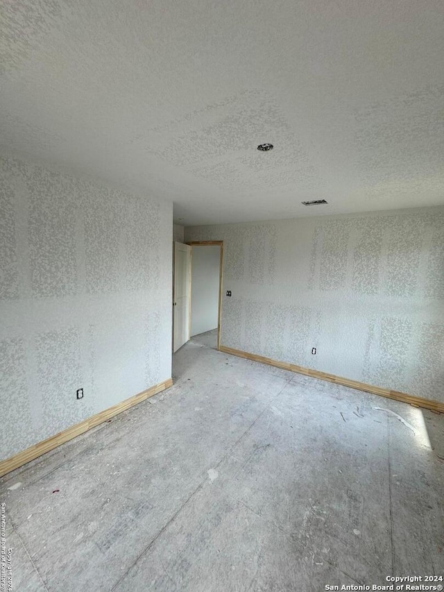 unfurnished room with a textured ceiling